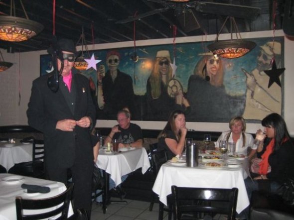 Frank X. Tolbert, standing on the right, with one of his large paintings in the background.